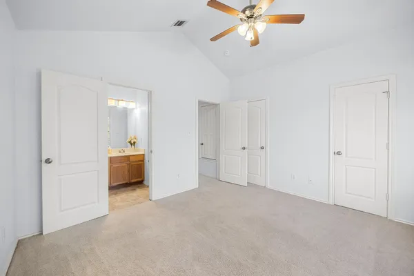 a view of a livingroom with a chandelier fan and windows