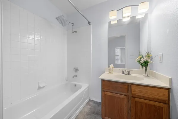 a bathroom with a tub sink and mirror
