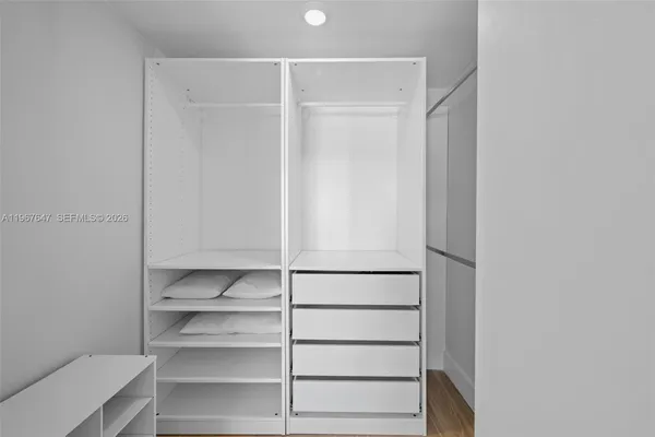 a view of walk in closet with empty racks