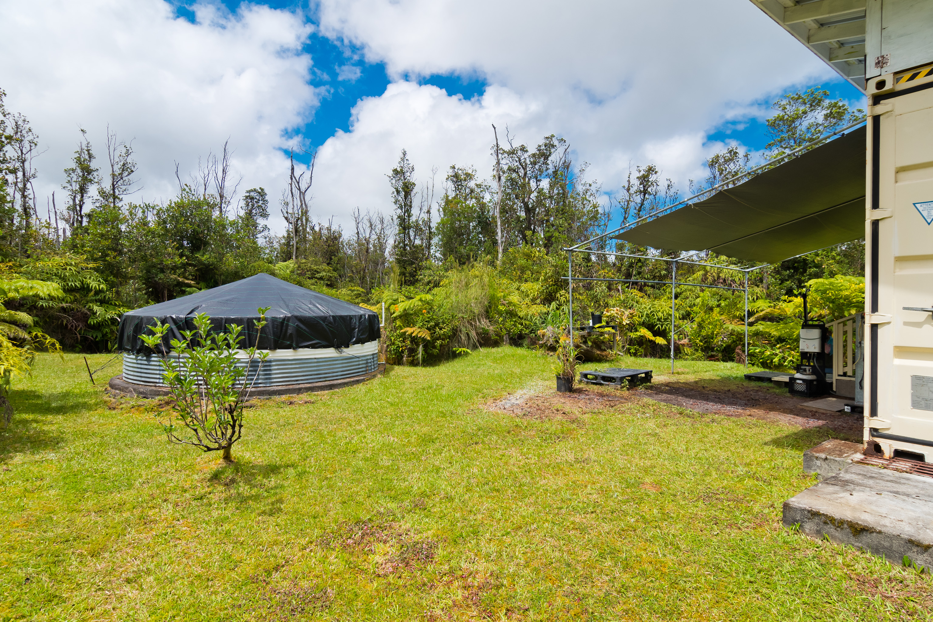 11-2430 Makoa Road Mountain View, HI 96771 - Photo 19 of 30 a view of a swimming pool with an outdoor seating and a yard