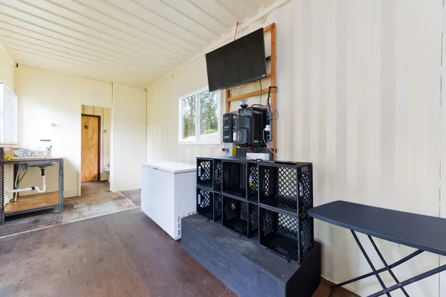 a living room with furniture a flat screen tv and kitchen view