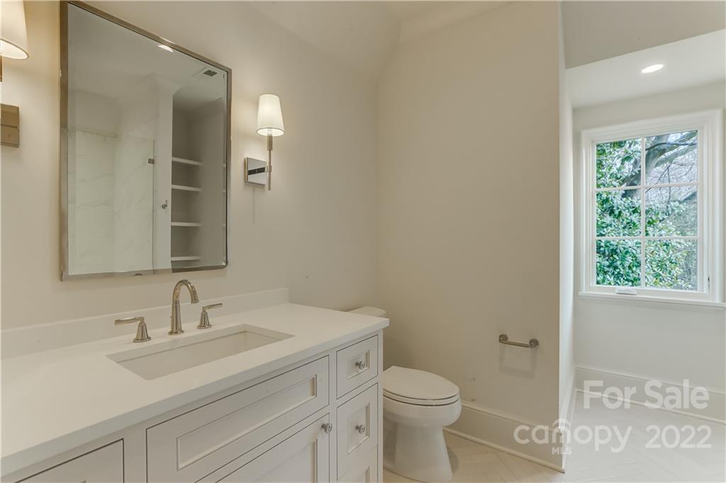1429 Audubon Road Charlotte, NC 28211 - Photo 37 of 48 a bathroom with a toilet a sink a mirror and a window