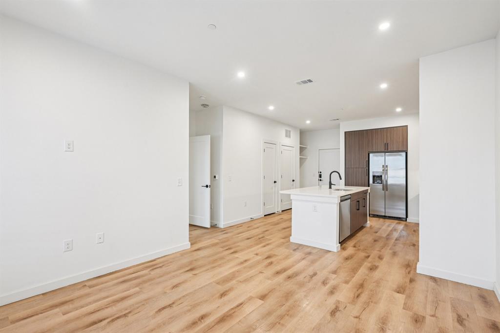 2016 South Ervay Street, Unit A1 Dallas, TX 75215 - Photo 35 of 35 Kitchen with a kitchen island with sink, stainless steel appliances, open floor plan, recessed lighting, and light wood finished floors