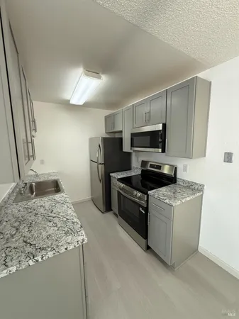 a kitchen with a stove a refrigerator and a sink