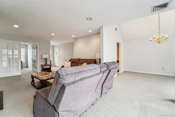 a living room with furniture a flat screen tv and dresser