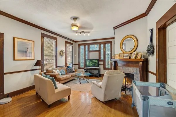 a living room with fireplace furniture and a large window
