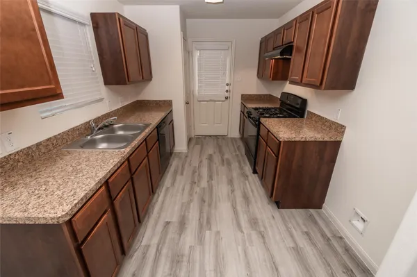 a kitchen with a sink and wooden cabinets