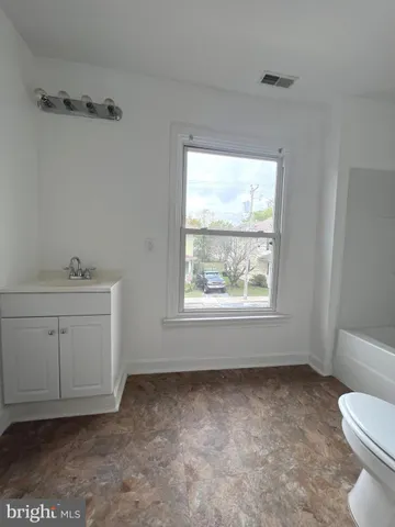 a bathroom with a sink toilet and window