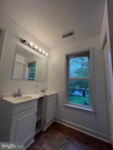 a bathroom with a double vanity sink and a mirror