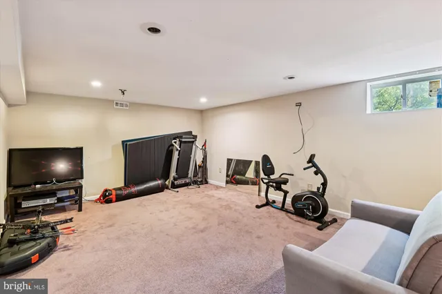 a view of a room with gym equipment and a flat screen tv