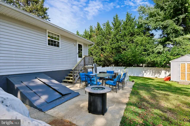 a view of a chairs and table in the back yard of the house
