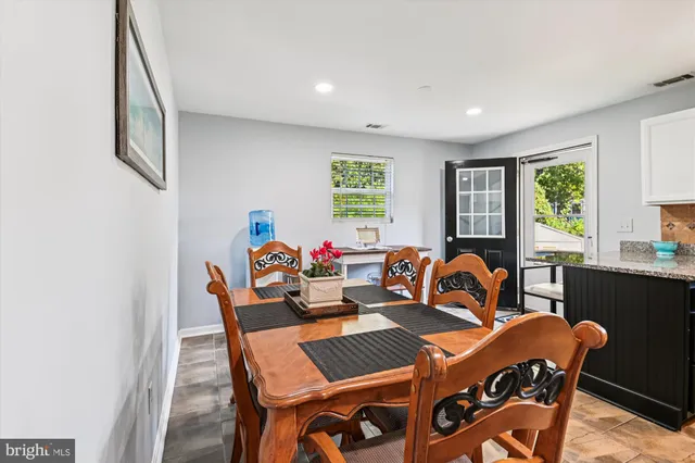 a view of a dining room with furniture a couch and wooden floor