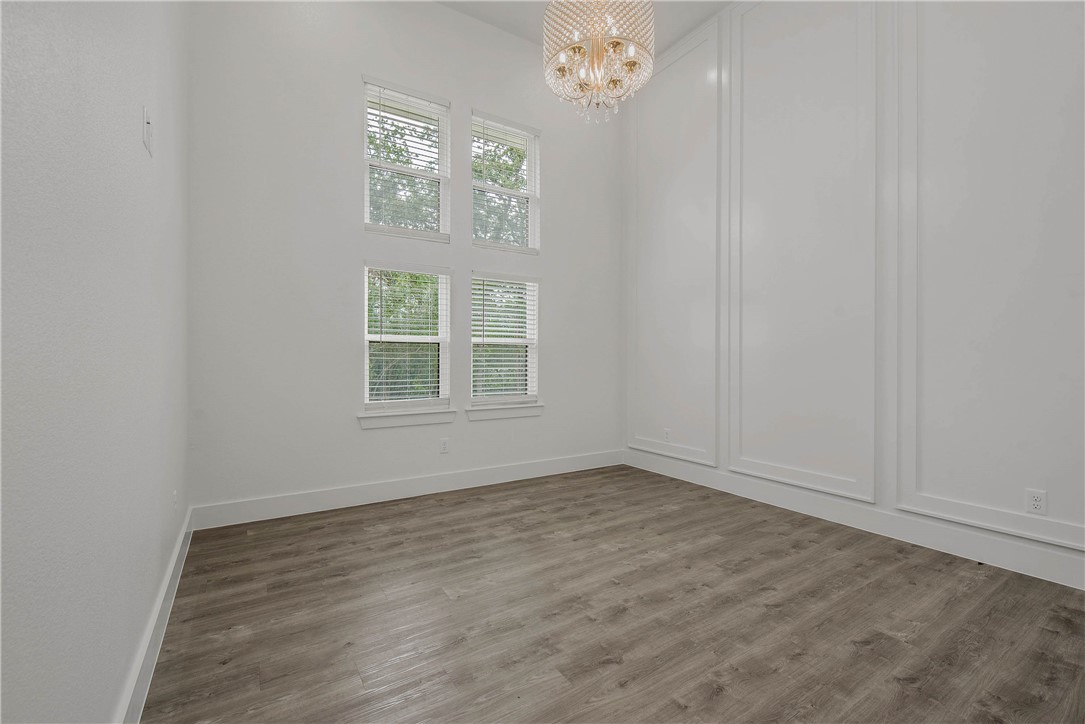2201 High Meadows Trail Franklin, TX 77856 - Photo 32 of 50 an empty room with wooden floor chandelier and windows