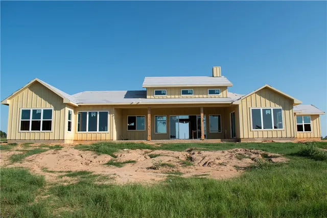an empty room with wooden floor cabinet and windows