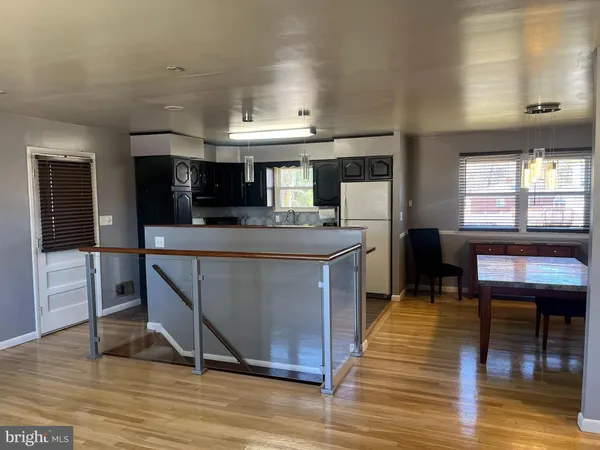a kitchen with stainless steel appliances granite countertop a stove top oven a sink dishwasher a dining table and chairs with wooden floor