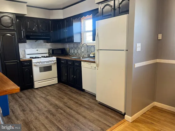 a kitchen with a refrigerator sink and cabinets