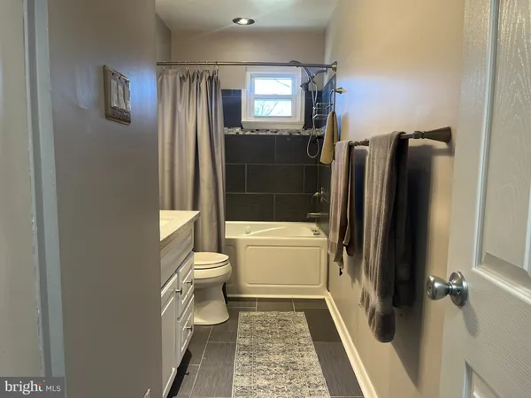 a bathroom with a granite countertop toilet shower and a mirror