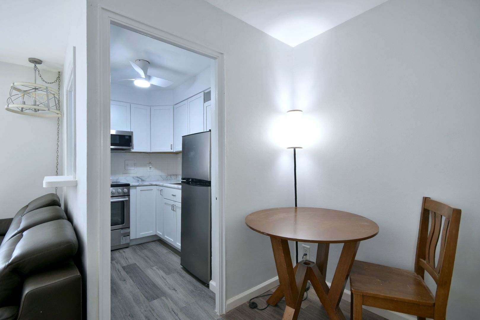 6118 North Sheridan Road, Unit 406 Chicago, IL 60660 - Photo 13 of 26 a kitchen with stainless steel appliances a refrigerator a stove a sink dishwasher and a dining table with wooden floor
