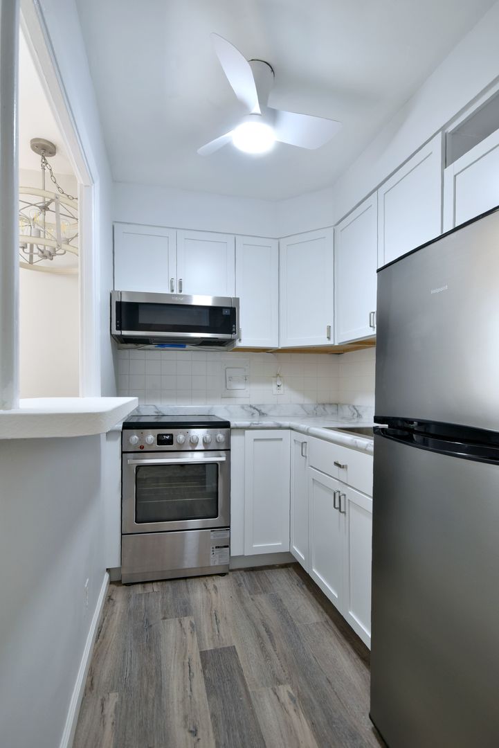 6118 North Sheridan Road, Unit 406 Chicago, IL 60660 - Photo 15 of 26 a kitchen with a refrigerator and a stove top oven