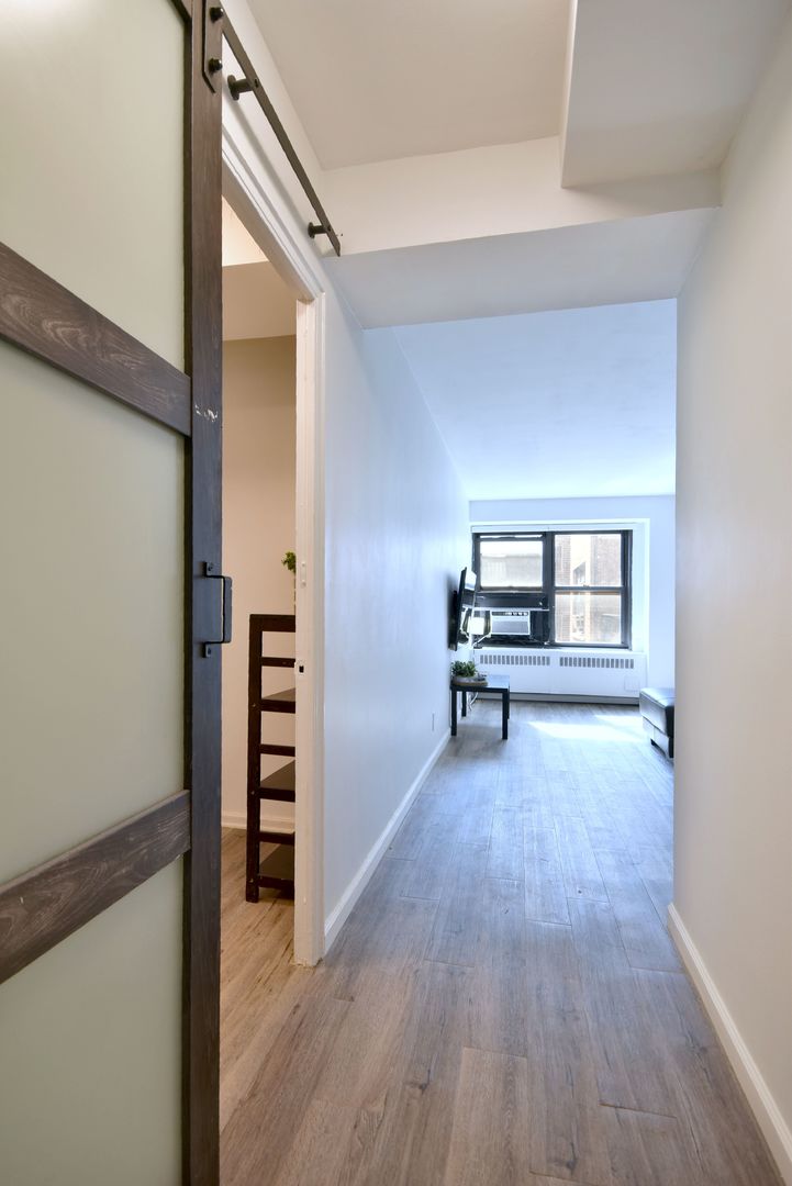 6118 North Sheridan Road, Unit 406 Chicago, IL 60660 - Photo 18 of 26 a view of a livingroom with wooden floor and furniture