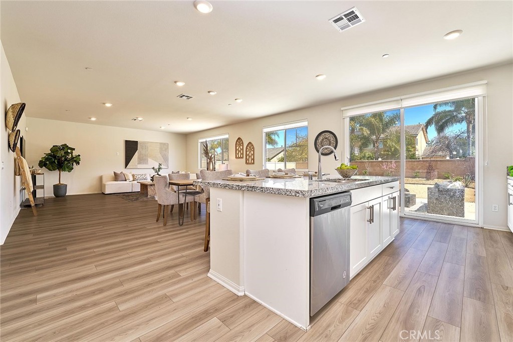 32846 Forgecroft Street Menifee, CA 92584 - Photo 13 of 48 a kitchen with stainless steel appliances granite countertop a stove and wooden floor