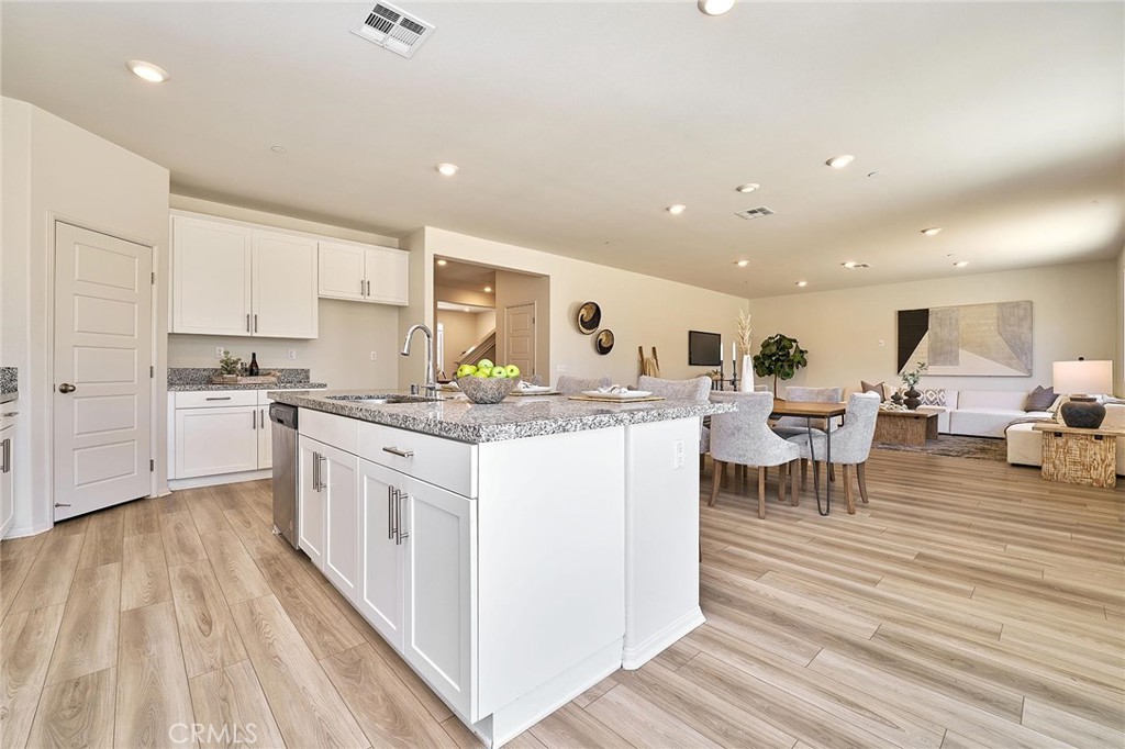 32846 Forgecroft Street Menifee, CA 92584 - Photo 16 of 48 a kitchen with stainless steel appliances granite countertop a stove top oven a sink dishwasher and white cabinets with wooden floor