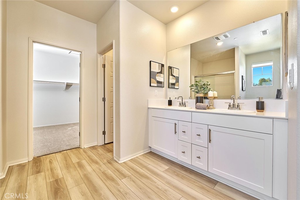 32846 Forgecroft Street Menifee, CA 92584 - Photo 26 of 48 a spacious bathroom with a double vanity sink and mirror