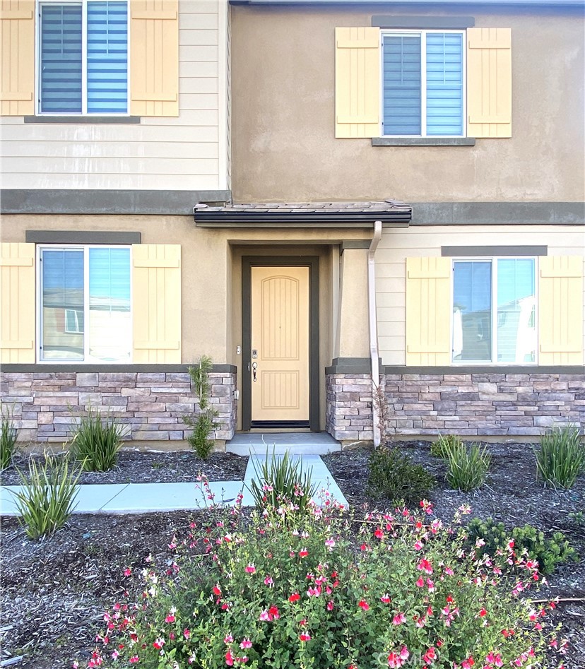 32846 Forgecroft Street Menifee, CA 92584 - Photo 45 of 48 a front view of a house with a yard and flowers