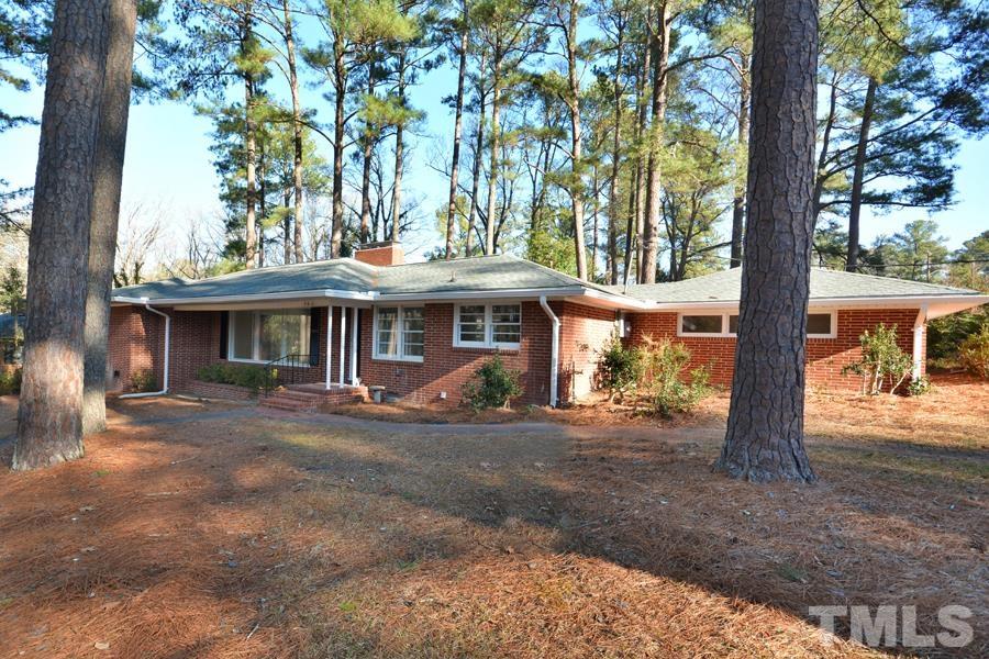 a view of a house with a porch and a large tree