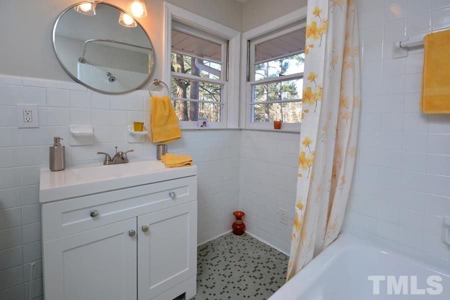 402 Monticello Avenue Durham, NC 27707 - Photo 24 of 24 a bathroom with a sink a mirror a vanity and window