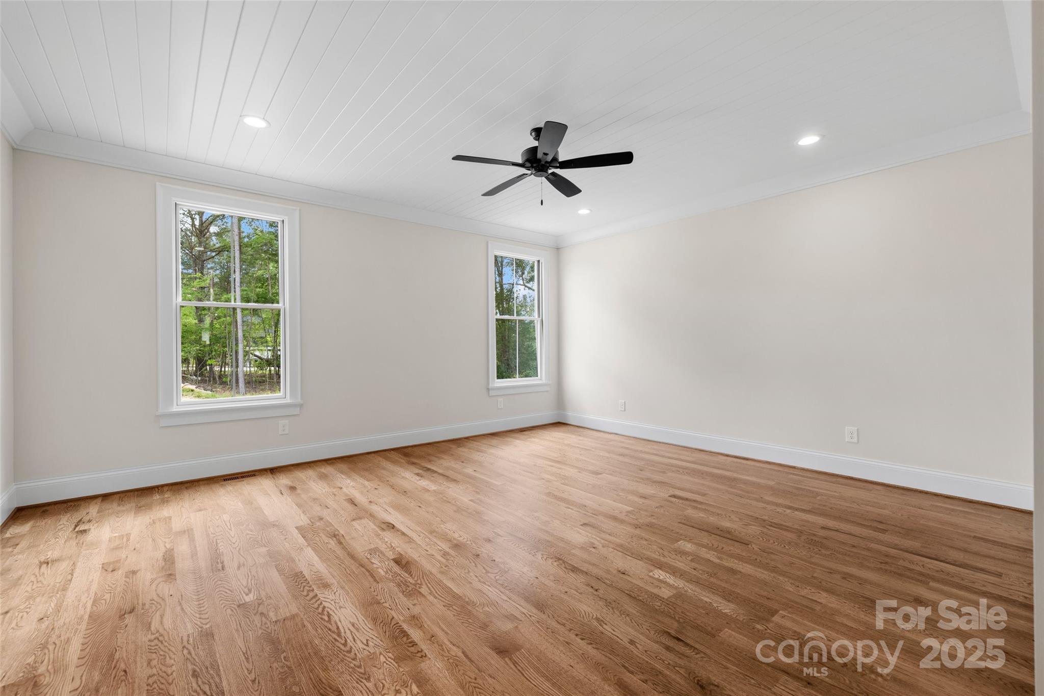 537 Riddle Mill Road Clover, SC 29710 - Photo 23 of 47 an empty room with wooden floor ceiling fan and windows