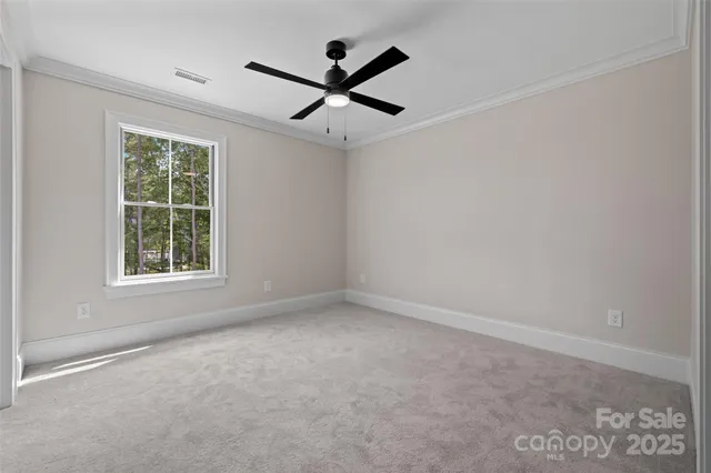 an empty room with ceiling fan and window
