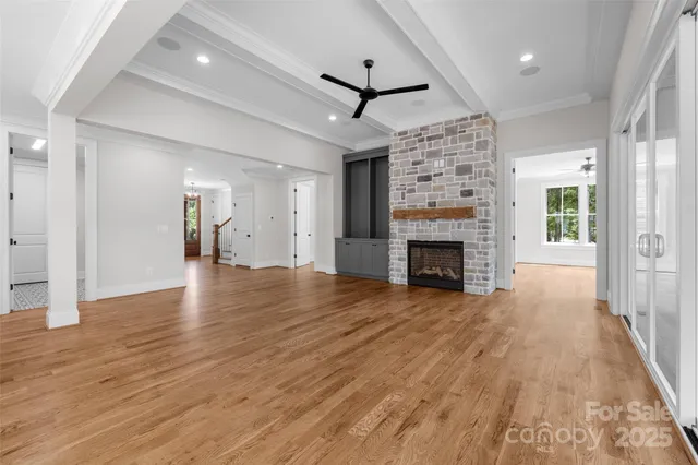 a view of a livingroom with wooden floor a fireplace and window
