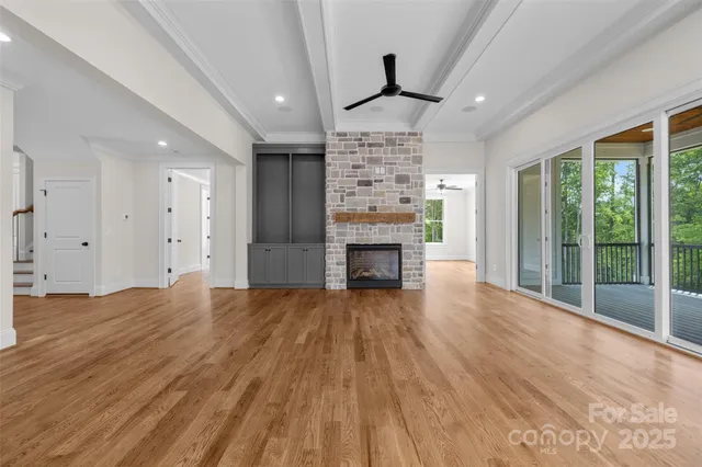 a view of empty room with wooden floor and fireplace