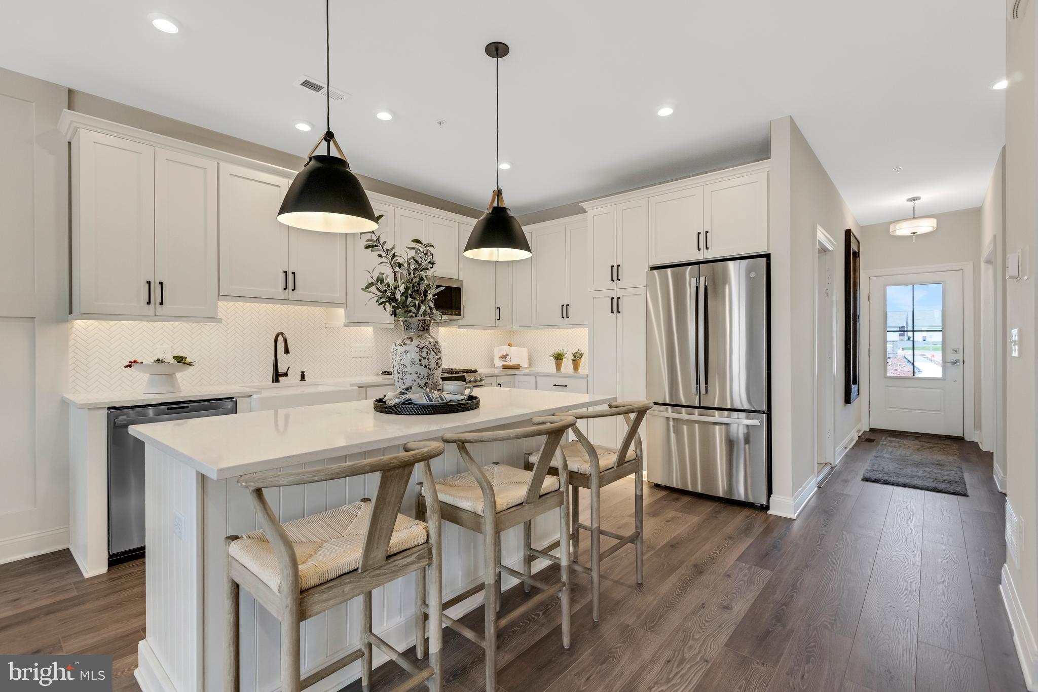 2 Baldwin Way Perkasie, PA 18944 - Photo 7 of 44 a kitchen with stainless steel appliances a dining table chairs stove and white cabinets