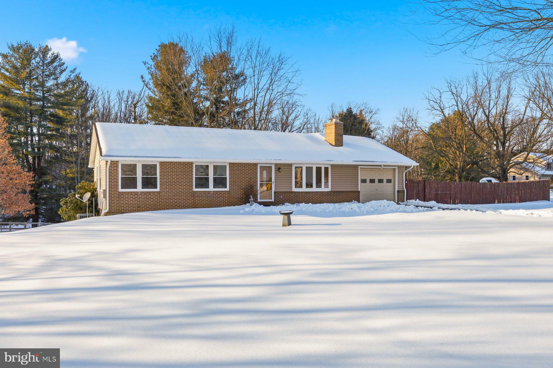 a front view of a house with a garden and trees