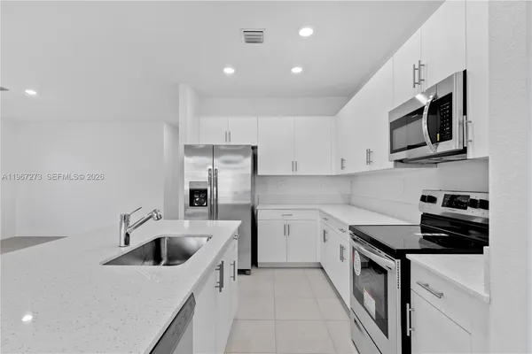 a kitchen with stainless steel appliances a refrigerator sink and microwave