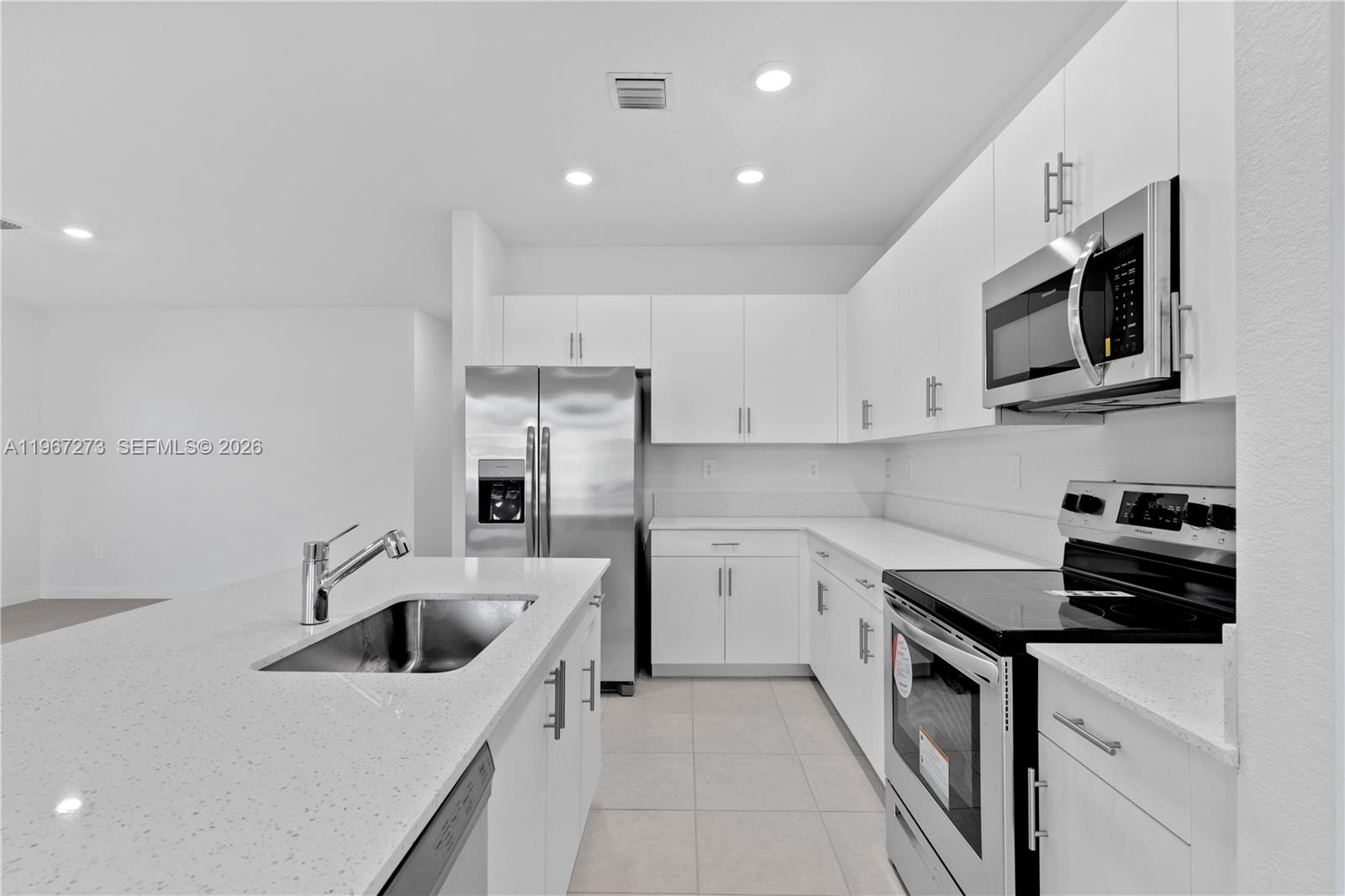 11947 Southwest 241 Terrace Homestead, FL 33032 - Photo 13 of 32 a kitchen with stainless steel appliances a stove a sink a microwave and cabinets