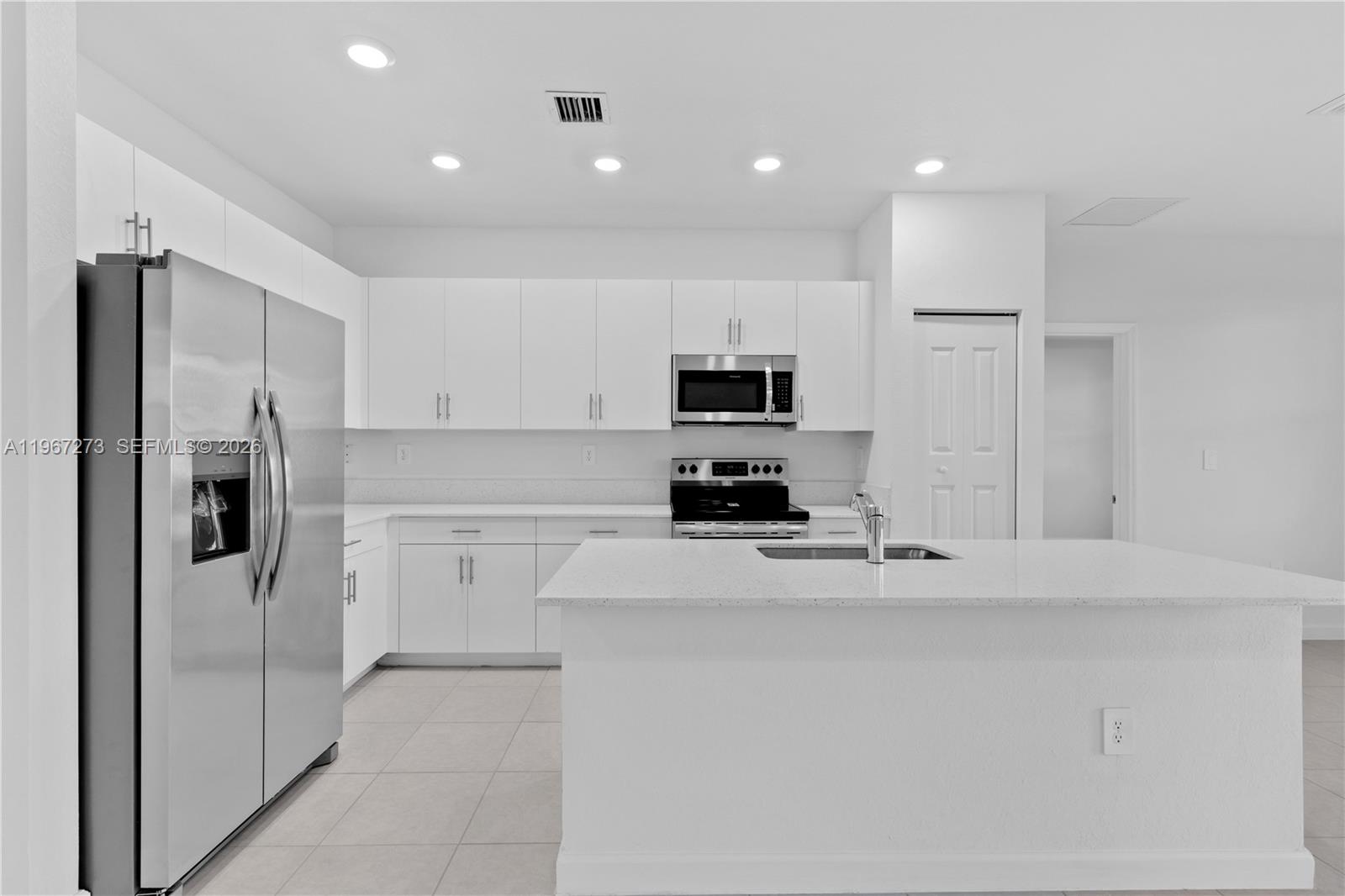 11947 Southwest 241 Terrace Homestead, FL 33032 - Photo 14 of 32 a kitchen with stainless steel appliances a refrigerator sink and microwave