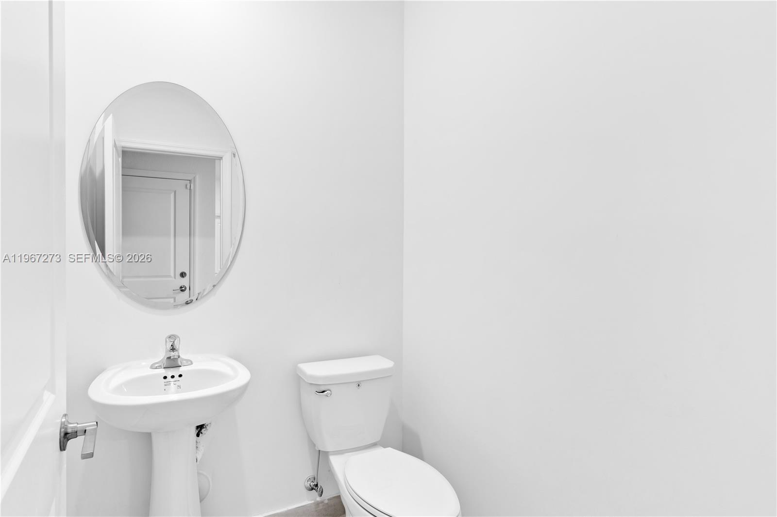 11947 Southwest 241 Terrace Homestead, FL 33032 - Photo 25 of 32 a bathroom with a toilet a sink and mirror