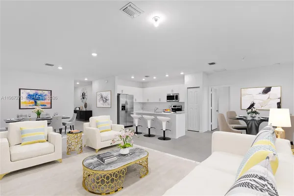 a living room with furniture and a view of kitchen