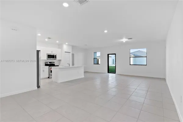 a view of kitchen with kitchen island white cabinets and stainless steel appliances