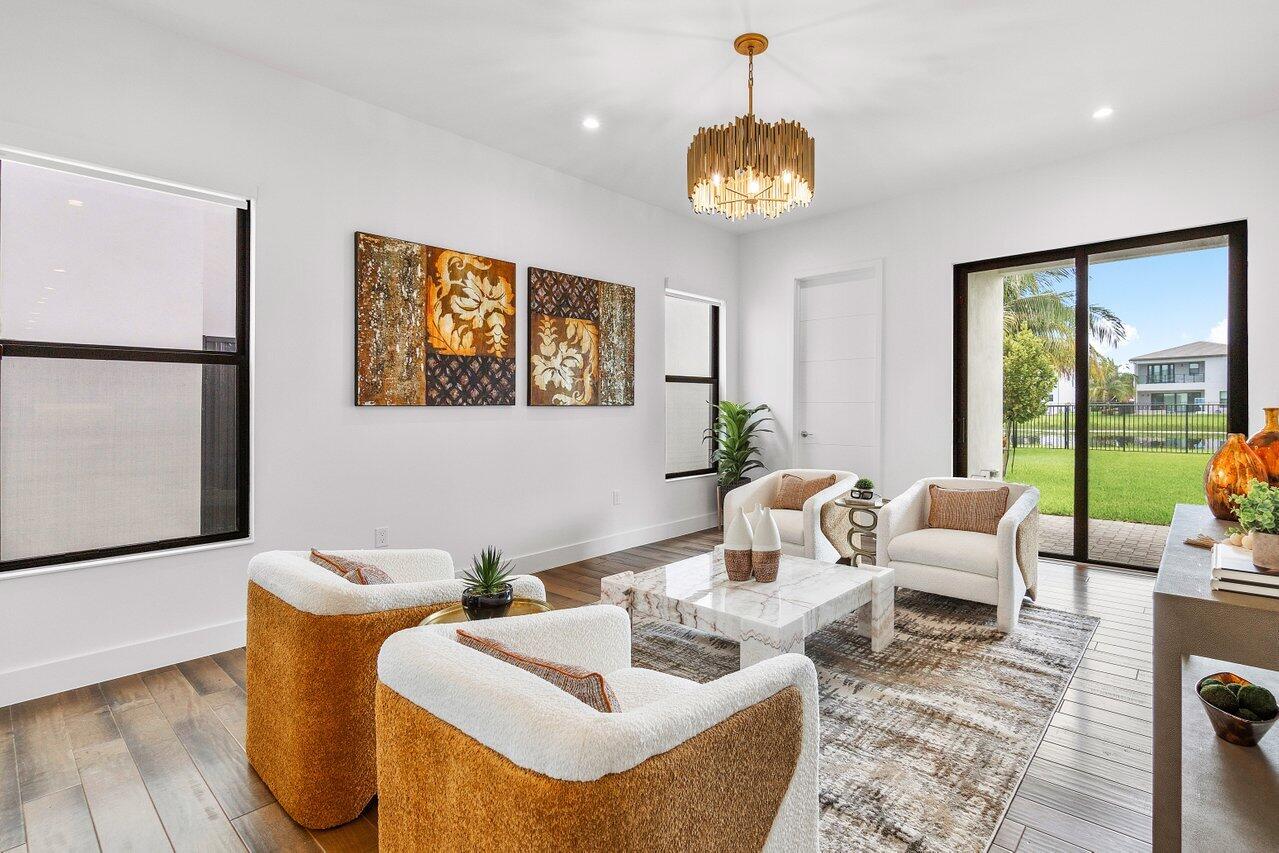 17128 Watersprite Lakes Road Boca Raton, FL 33496 - Photo 12 of 56 a living room with furniture and a chandelier