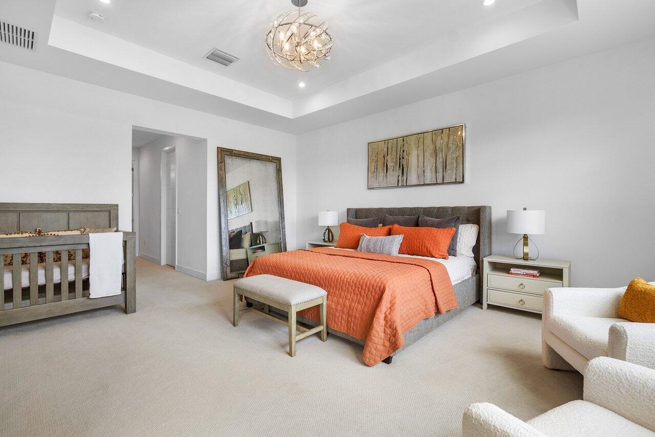 17128 Watersprite Lakes Road Boca Raton, FL 33496 - Photo 21 of 56 a bedroom with a bed and a chandelier