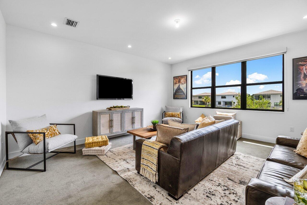 17128 Watersprite Lakes Road Boca Raton, FL 33496 - Photo 25 of 56 a living room with furniture and a flat screen tv