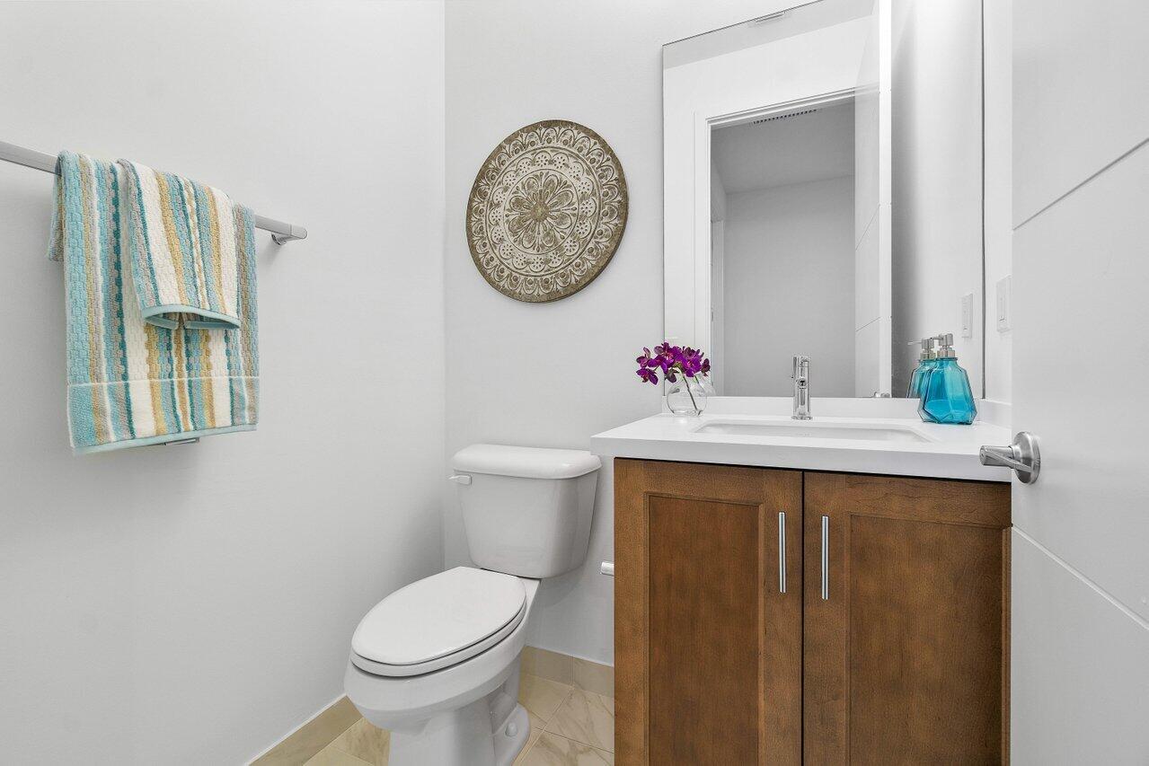 17128 Watersprite Lakes Road Boca Raton, FL 33496 - Photo 26 of 56 a bathroom with a toilet a sink and a mirror