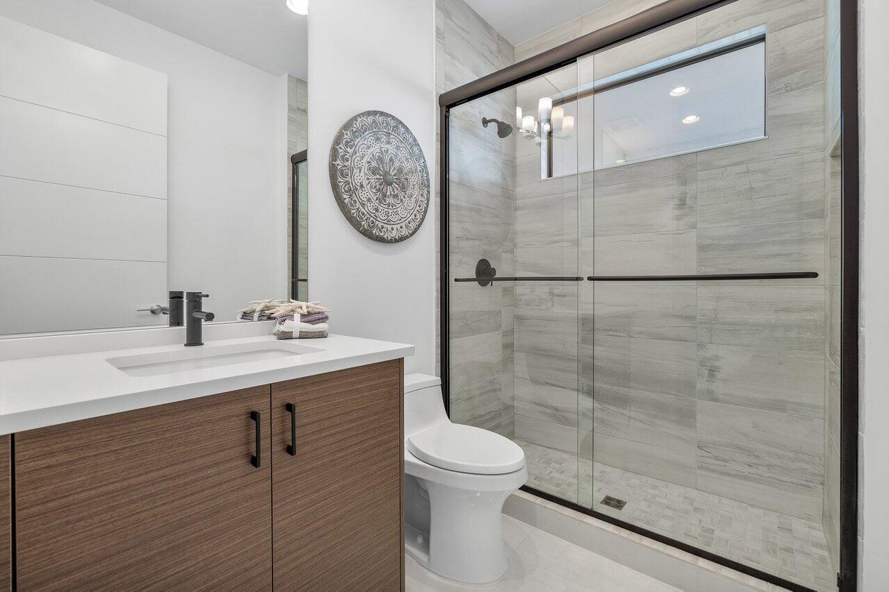 17128 Watersprite Lakes Road Boca Raton, FL 33496 - Photo 31 of 56 a bathroom with a sink mirror and toilet