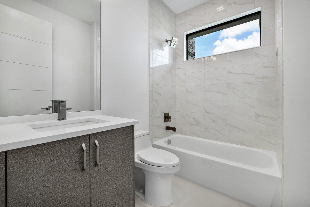 17128 Watersprite Lakes Road Boca Raton, FL 33496 - Photo 32 of 56 a bathroom with a sink a toilet and a bathtub