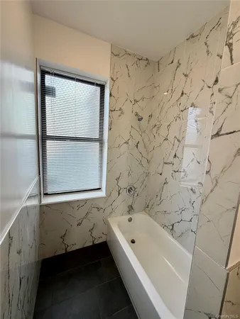 a bathroom with a bathtub and a window