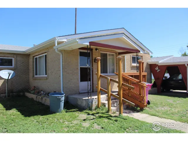 a view of a house with a yard and sitting area